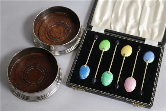 A cased set of six silver and enamel bean end coffee spoons and a pair of modern silver mounted wine coasters.